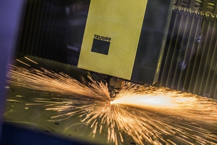 close-up van TRUMPF lasersnijmachine die metaal snijdt met heldere vonken in industriële werkomgeving