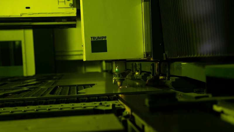 TRUMPF industriële lasersnijmachine met groene laserstraal snijdt nauwkeurig metalen plaat – geavanceerde technologie voor metaalbewerking en geautomatiseerde productie.