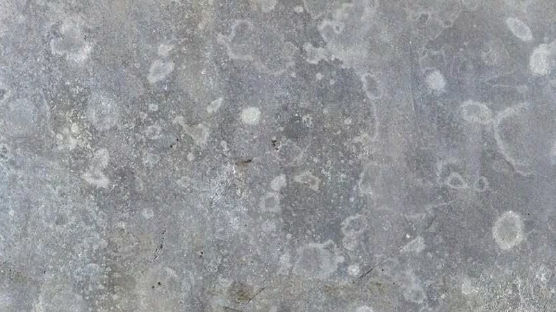 Close-up van aluminium met corrosie, zichtbaar als witte en grijze vlekken op het oppervlak.