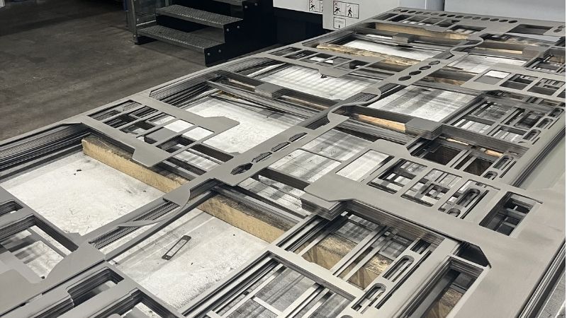 Precisie-gesneden metalen platen met diverse geometrische uitsparingen, geproduceerd via CNC of laserbewerking voor industriële toepassingen zoals behuizingen en montagedelen.