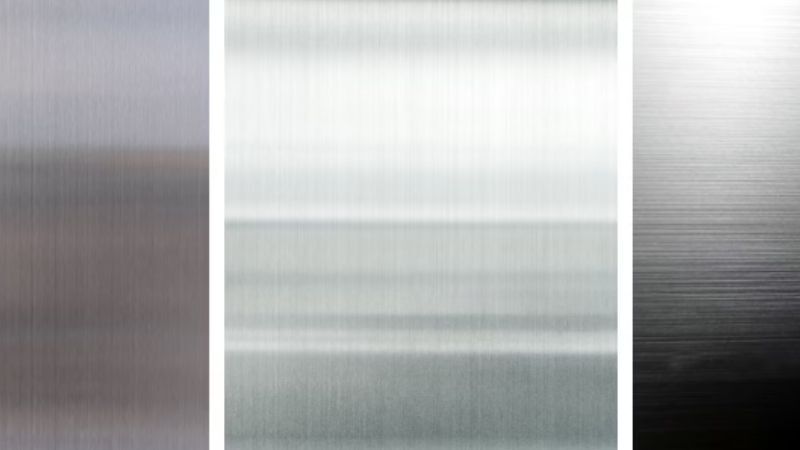 Drie geborstelde metaalstalen naast elkaar: links donkerblauwgrijs met fijne horizontale lijnen, midden zilverwit met egaal patroon, rechts donker met verloop en uitgesproken borstelstreken.