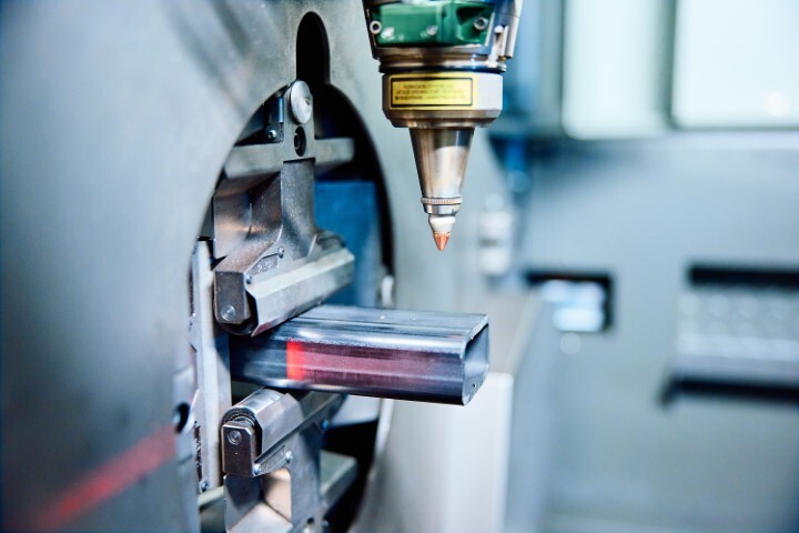 Automatische lasermachine bewerkt een metalen buis met hoge precisie in een geavanceerde productieomgeving.